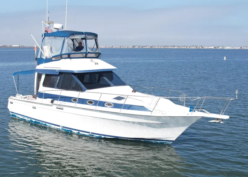 The Image of 1988 Mediterranean 38 Convertible yacht on calm water, featuring a sleek white and blue design. - 0