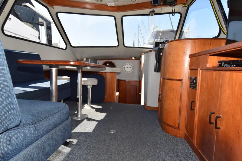 Slide: The Image of Interior of 1988 Mediterranean 38 Convertible yacht with blue seating and wooden cabinetry. - 10