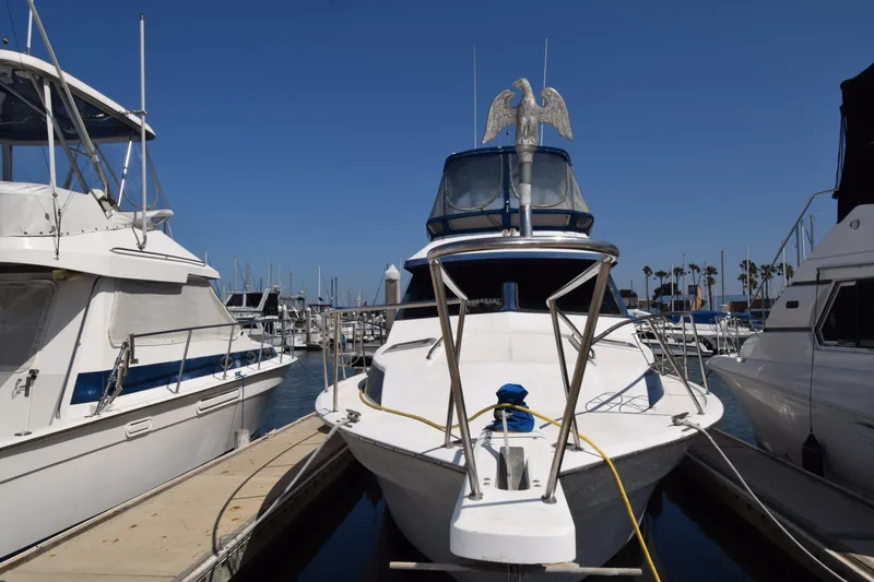 Slide: The Image of 1988 Mediterranean 38 Convertible yacht docked at marina under clear blue sky. - 12