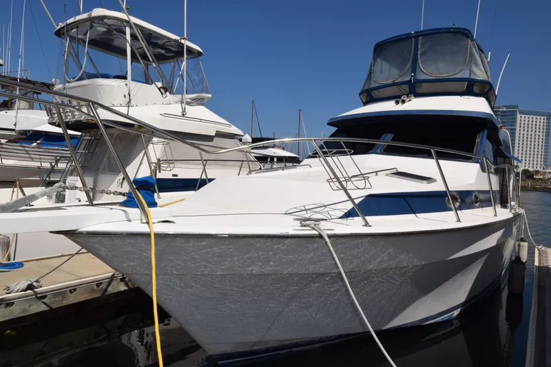 Slide: The Image of 1988 Mediterranean 38 Convertible yacht docked at marina under clear blue sky. - 16