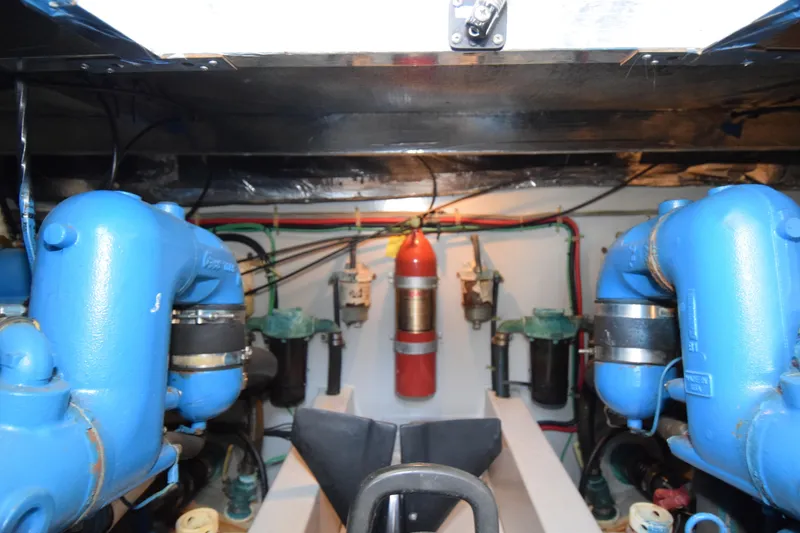 Slide: The Image of Engine room of 1988 Mediterranean 38 Convertible with blue machinery and fire extinguisher. - 23
