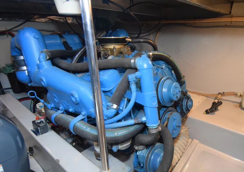 Slide: The Image of Engine room of 1988 Mediterranean 38 Convertible with blue marine engine components. - 24