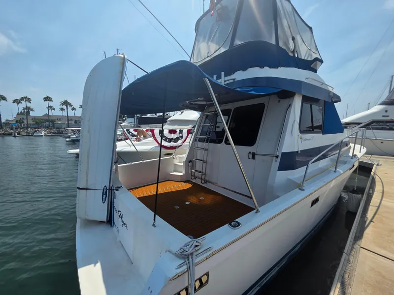Slide: The Image of 1988 Mediterranean 38 Convertible yacht docked at marina, featuring spacious deck and sleek design. - 3