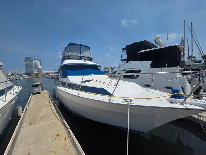 Slide: The Image of 1988 Mediterranean 38 Convertible yacht docked at marina under clear blue sky. - 4