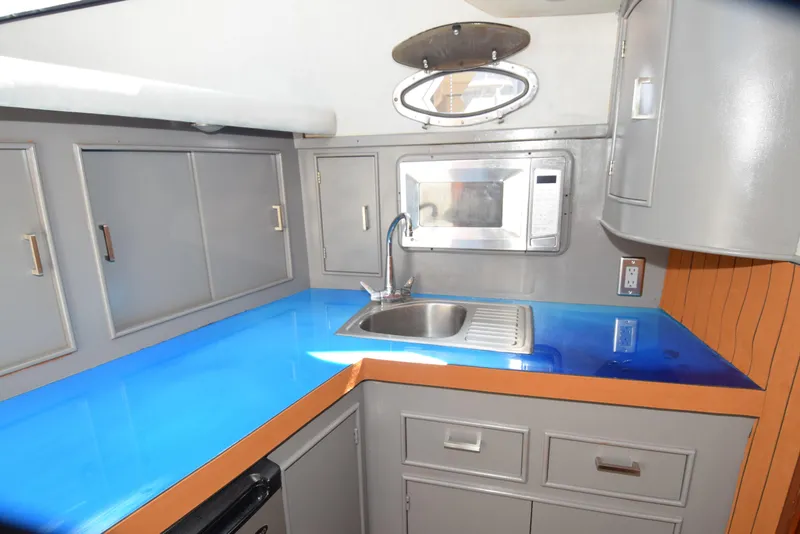Slide: The Image of 1988 Mediterranean 38 Convertible yacht kitchen with blue countertop, sink, and microwave. - 9