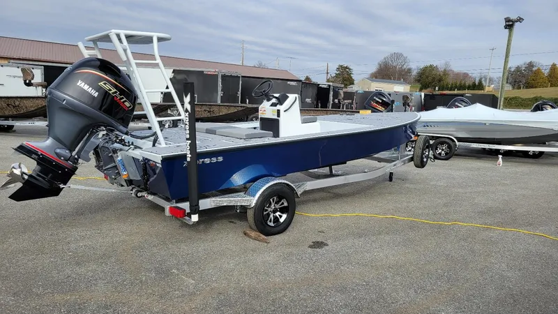 Slide: The Image of 2025 Xpress Skiff 185 with Yamaha Vmax 115 SHO, blue, on trailer, outdoor display. - 1