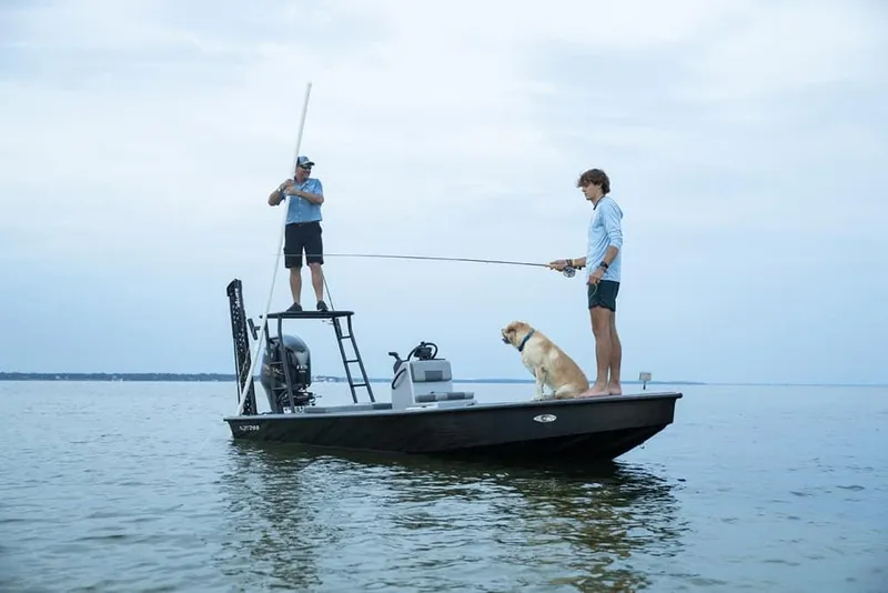 Slide: The Image of Two people and a dog fishing on Xpress Skiff 185 boat, 2025 model. - 2