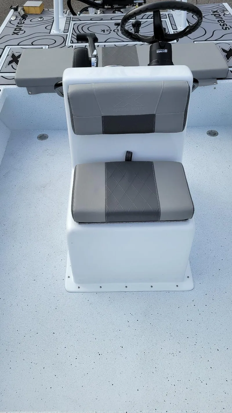 Slide: The Image of 2025 Xpress Skiff 185 boat interior with steering wheel and seating. - 22