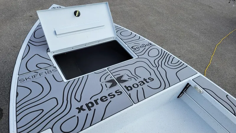 Slide: The Image of 2025 Xpress Skiff 185 boat deck with storage compartment, featuring SeaDek non-slip surface. - 7