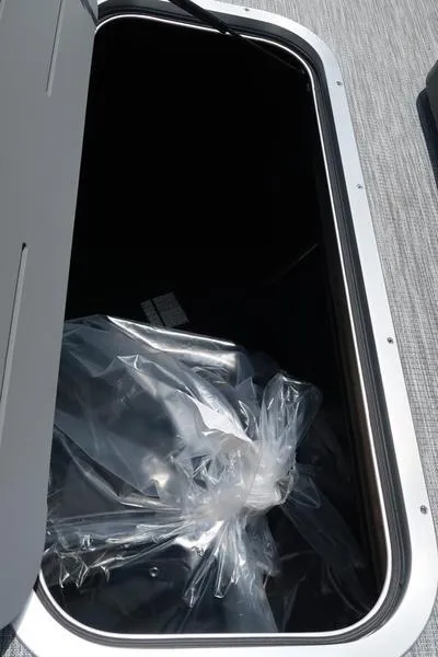 Slide: The Image of Storage compartment of 2025 Bennington S Swingback 22 SSB with plastic bag inside. - 13