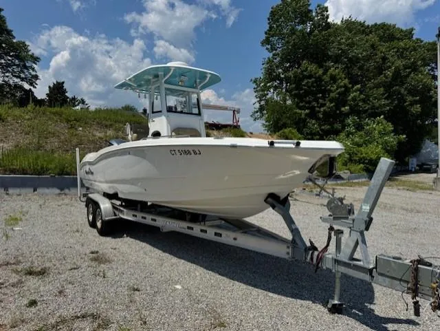 Slide: The Image of 2019 NauticStar 251 Hybrid boat on trailer, parked outdoors under a partly cloudy sky. - 4