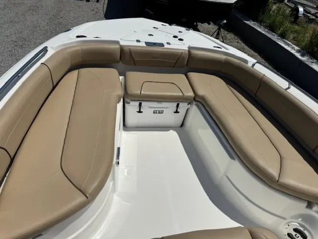 Slide: The Image of 2019 NauticStar 251 Hybrid boat interior with tan seating and YETI cooler. - 7