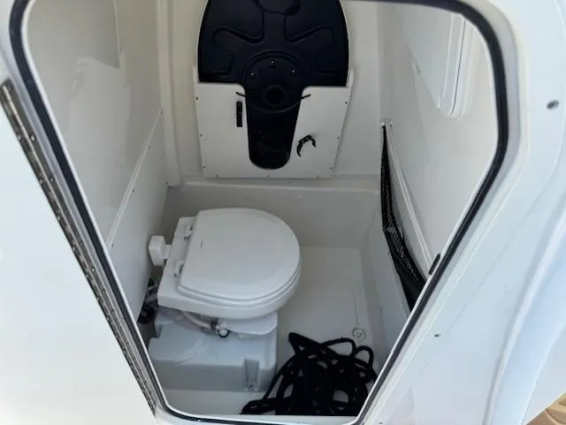 Slide: The Image of 2019 NauticStar 251 Hybrid boat interior with compact marine toilet. - 9
