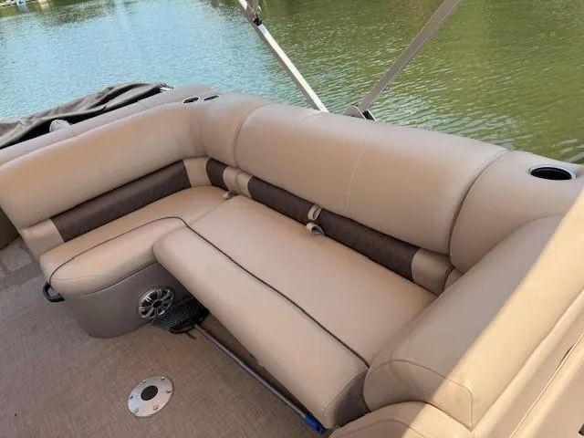 Slide: The Image of 2023 Sun Tracker Fishin' Barge 20 DLX boat with beige seating by the water. - 5