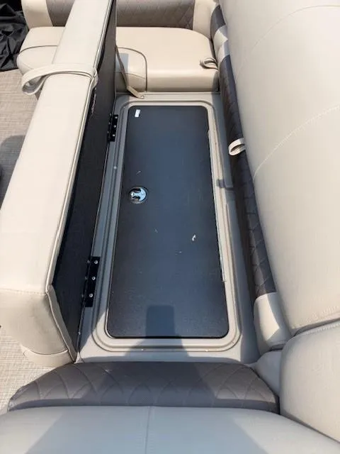 Slide: The Image of 2023 Sun Tracker Fishin' Barge 20 DLX storage compartment with beige seating. - 6