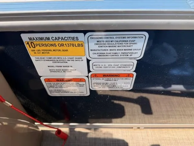 Slide: The Image of 2023 Sun Tracker Fishin' Barge 20 DLX capacity and emissions warning labels. - 9