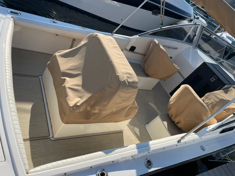 Slide: The Image of 1998 Albemarle 247 Cuddy Express boat interior with white seating and American flag. - 3