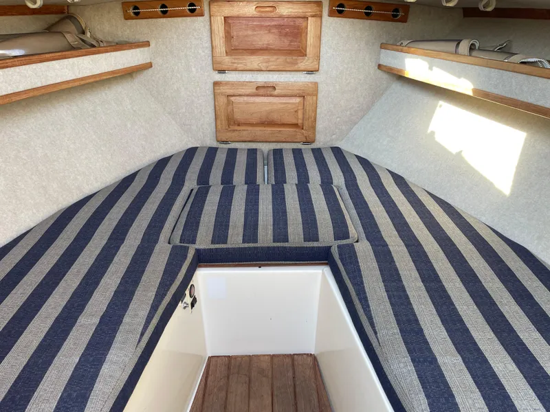 Slide: The Image of 1998 Albemarle 247 Cuddy Express interior with striped cushions and wooden storage compartments. - 4