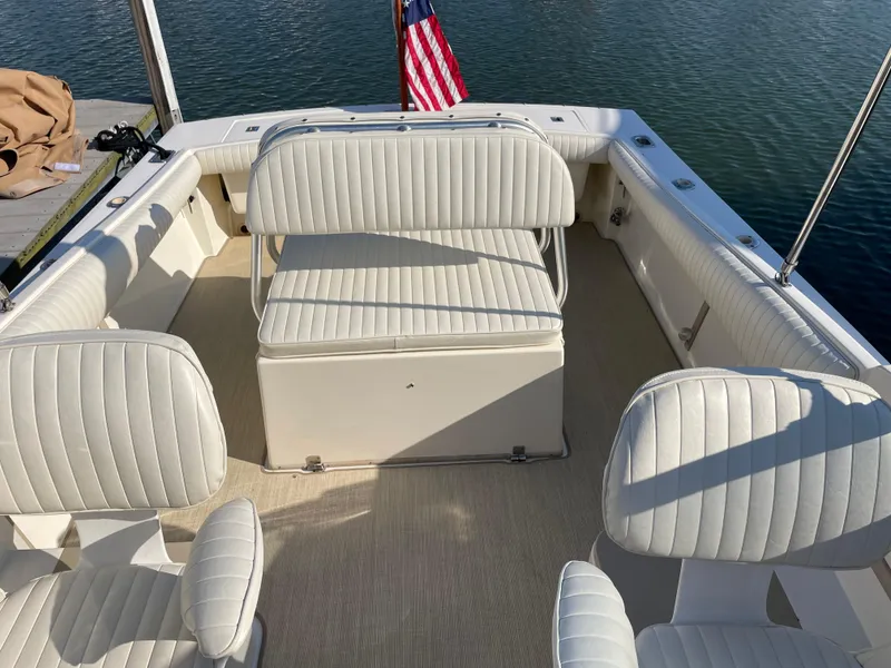 Slide: The Image of 1998 Albemarle 247 Cuddy Express boat interior with cushioned seating and water view. - 7