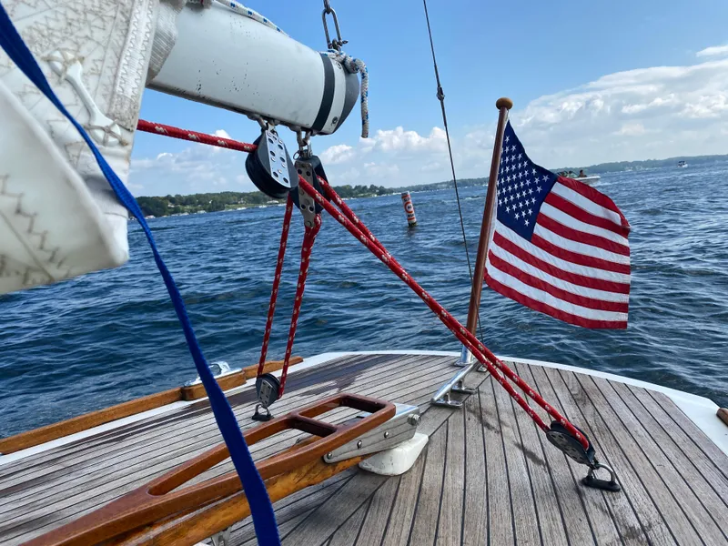 Slide: The Image of Tofinou 7 sailboat deck with American flag, sailing on a sunny day, 1998 model. - 15
