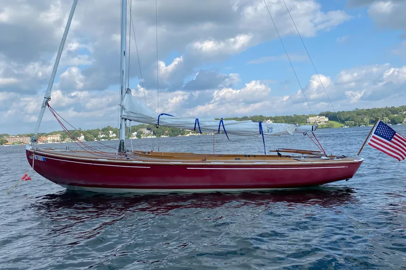 Slide: The Image of Red 1998 Tofinou 7 sailboat on a lake, American flag, cloudy sky. - 16