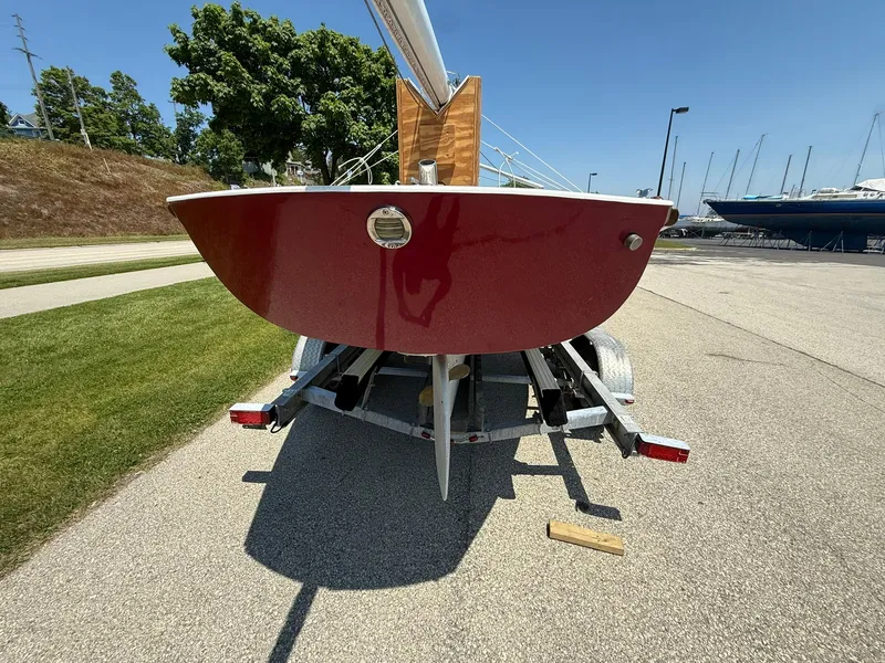 Slide: The Image of Red 1998 Tofinou 7 sailboat on trailer, parked on sunny marina pavement. - 3