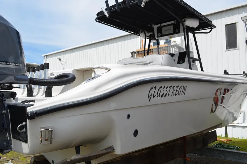 Slide: The Image of 2005 Glasstream 328 SCX boat with outboard motor, docked near a white building. - 10