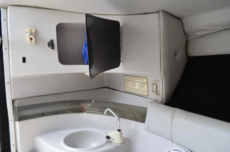 Slide: The Image of Interior of 2005 Glasstream 328 SCX boat, featuring a compact sink and storage area. - 45