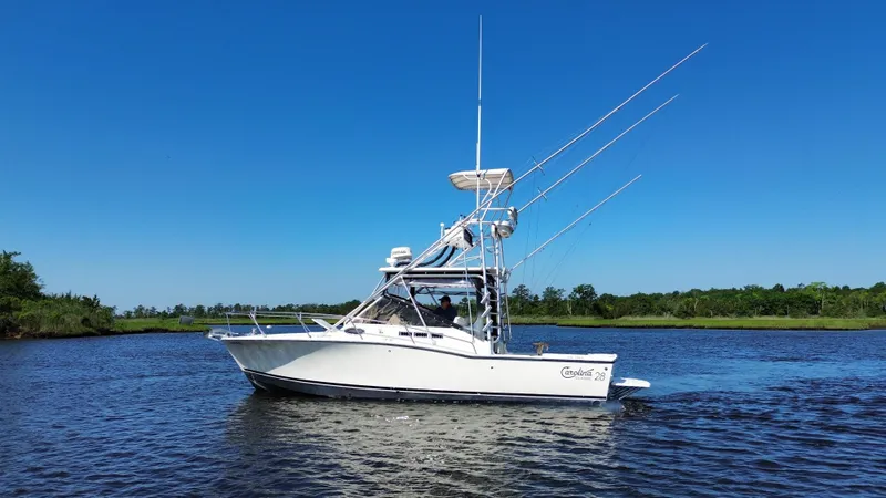 Slide: The Image of 2004 Carolina Classic 28 boat on calm water under clear blue sky. - 10