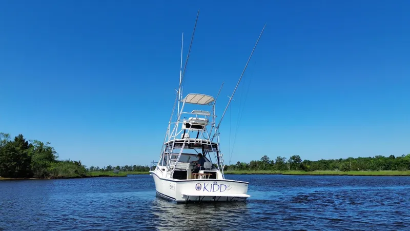 Slide: The Image of 2004 Carolina Classic 28 boat on a calm river under clear blue sky. - 11
