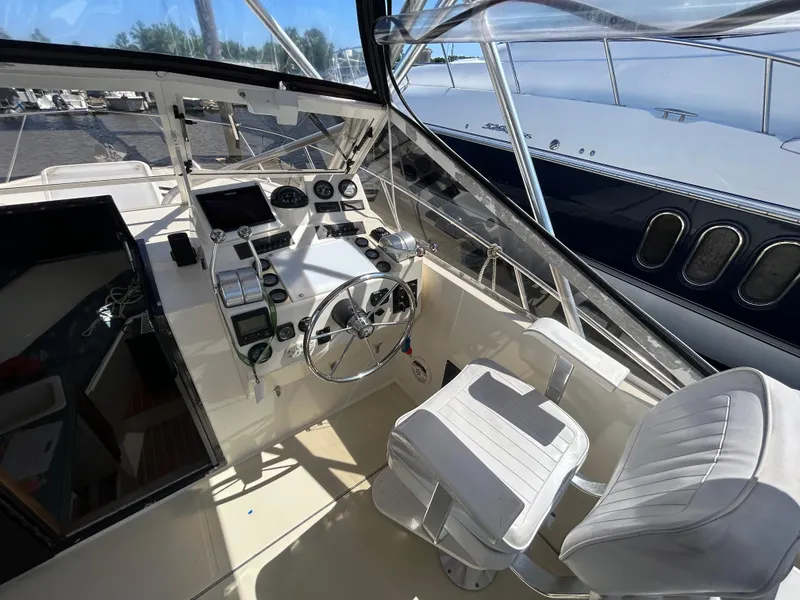 Slide: The Image of 2004 Carolina Classic 28 boat cockpit with steering wheel and control panel. - 16