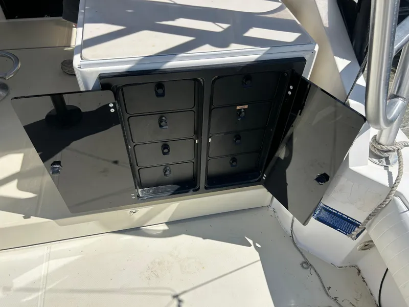 Slide: The Image of Open storage compartment on a 2004 Carolina Classic 28 boat, featuring multiple drawers. - 18