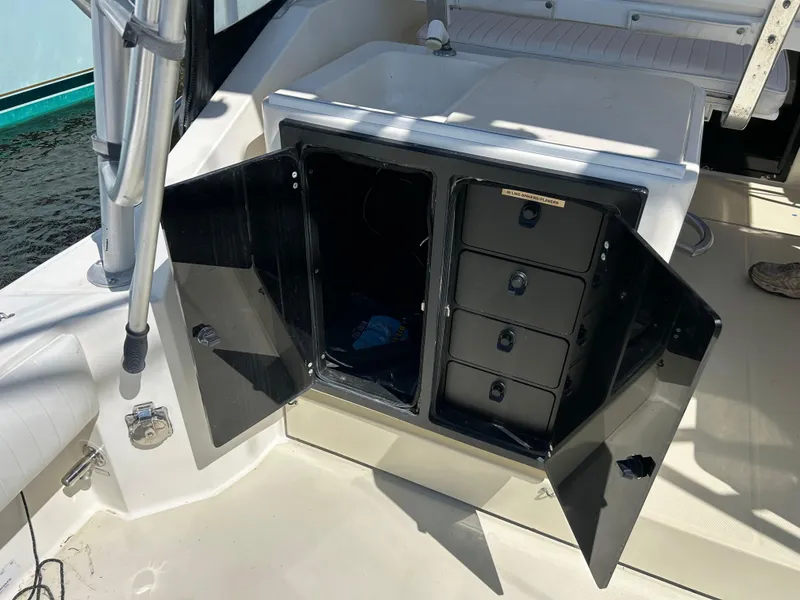 Slide: The Image of Open storage compartment on a 2004 Carolina Classic 28 boat, featuring multiple drawers. - 19