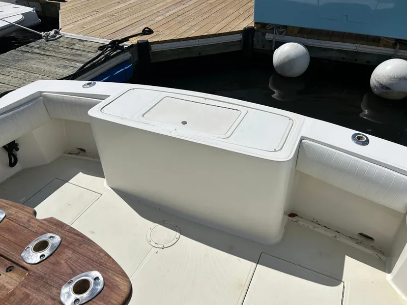 Slide: The Image of 2004 Carolina Classic 28 boat interior with seating and storage at dock. - 20