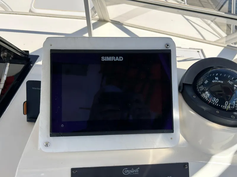 Slide: The Image of Simrad display and compass on 2004 Carolina Classic 28 boat dashboard. - 27
