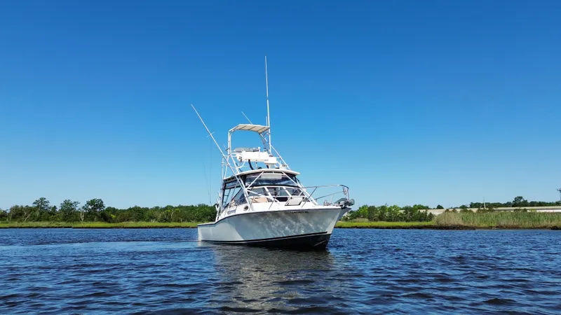 Slide: The Image of 2004 Carolina Classic 28 boat on calm water under clear blue sky. - 3