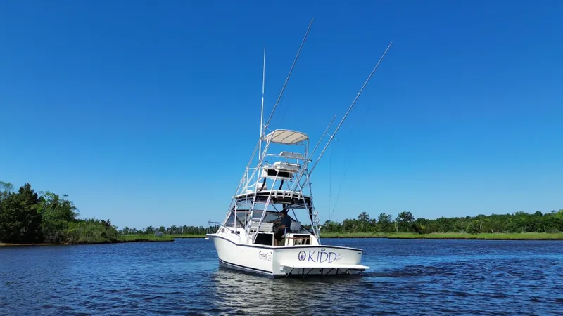 Slide: The Image of 2004 Carolina Classic 28 boat on a calm river under clear blue sky. - 4