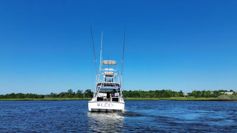 Slide: The Image of 2004 Carolina Classic 28 boat cruising on a calm river under a clear blue sky. - 6