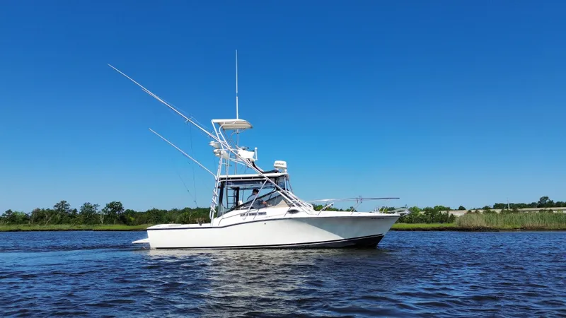 Slide: The Image of 2004 Carolina Classic 28 boat on calm water under clear blue sky. - 8
