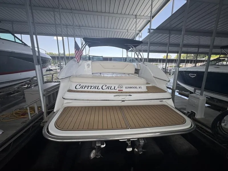 Slide: The Image of 2002 Sea Ray 290 boat docked, featuring teak swim platform and "Capital Call" name. - 0