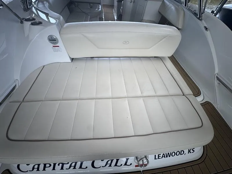 Slide: The Image of 2002 Sea Ray 290 boat interior with beige seating and wood flooring. - 2
