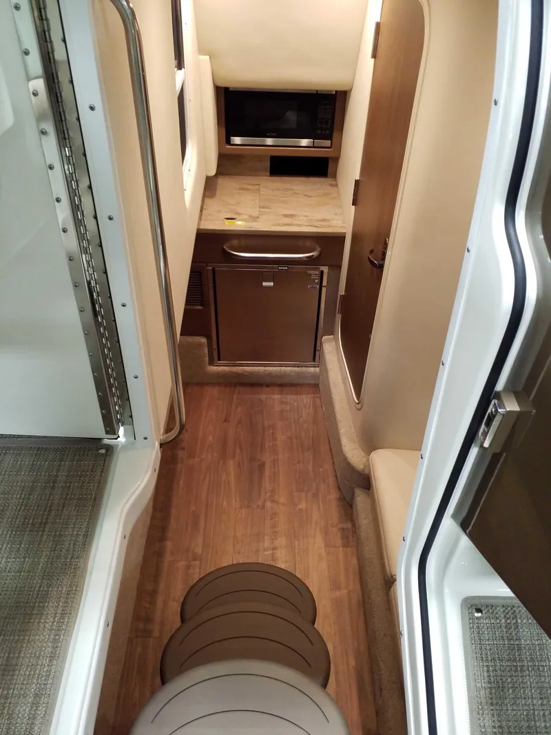 Slide: The Image of 2019 Formula 350 Crossover Bowrider OB interior with kitchenette and wood flooring. - 14