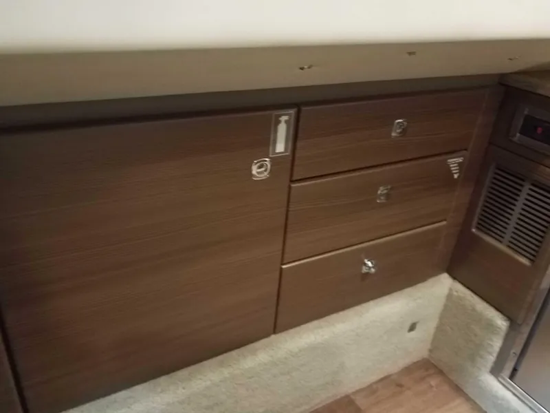 Slide: The Image of 2019 Formula 350 Crossover Bowrider OB interior cabinetry with wood finish and storage drawers. - 16