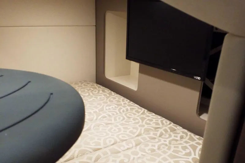 Slide: The Image of 2019 Formula 350 Crossover Bowrider OB cabin interior with TV and patterned bedding. - 19