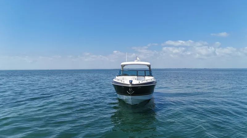 Slide: The Image of 2019 Formula 350 Crossover Bowrider OB on open water under clear blue sky. - 35