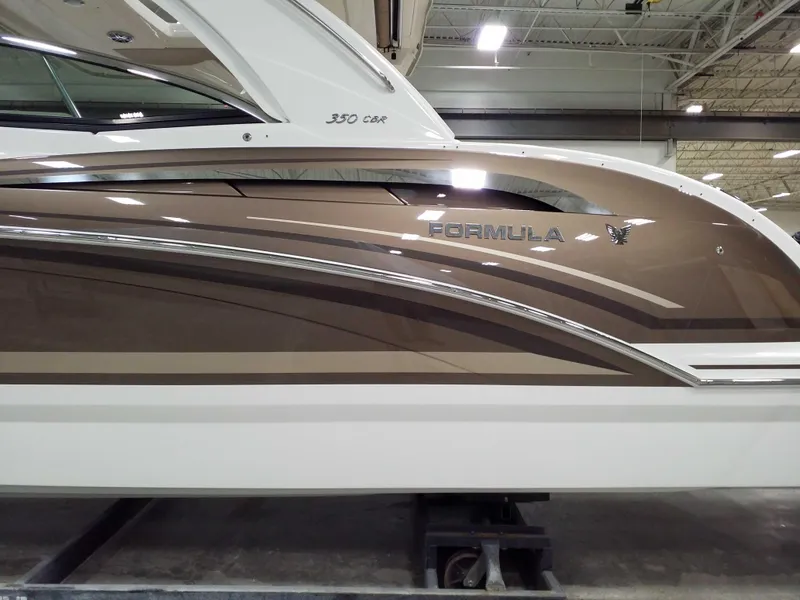 Slide: The Image of 2019 Formula 350 Crossover Bowrider OB, sleek brown and white design in a showroom. - 7