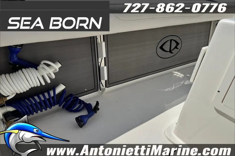 Slide: The Image of 2025 Sea Born LX24 Center Console boat interior with storage compartments and coiled hoses. - 24