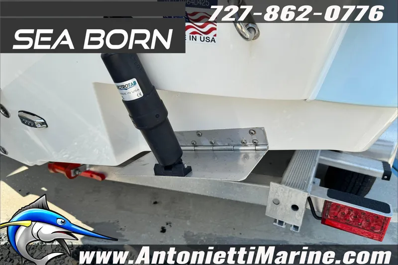 Slide: The Image of 2025 Sea Born LX24 Center Console boat on trailer, featuring trim tab and branding. - 48
