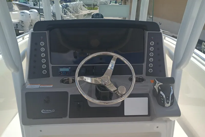 Slide: The Image of 2025 Robalo R230 Center Console boat dashboard with steering wheel and controls. - 10