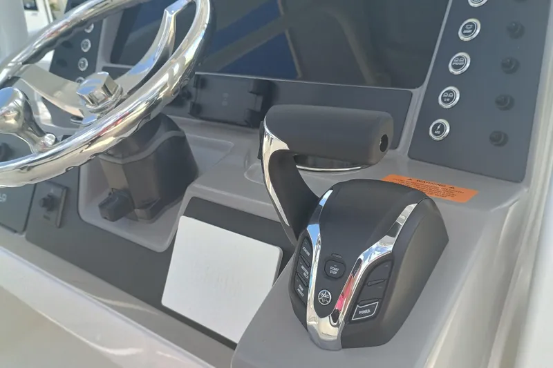 Slide: The Image of 2025 Robalo R230 Center Console boat dashboard with steering wheel and controls. - 13